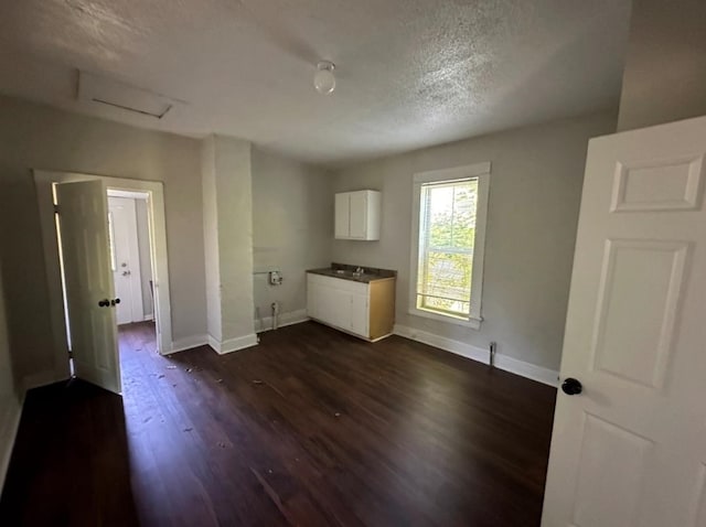 unfurnished room with dark hardwood / wood-style flooring and a textured ceiling