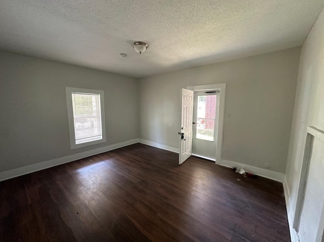 spare room with dark wood-type flooring and a textured ceiling