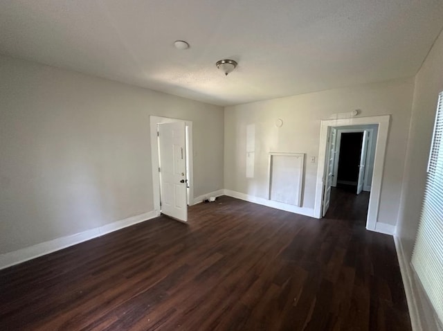 empty room with dark hardwood / wood-style flooring