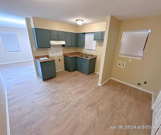 kitchen with a textured ceiling, light hardwood / wood-style floors, and sink