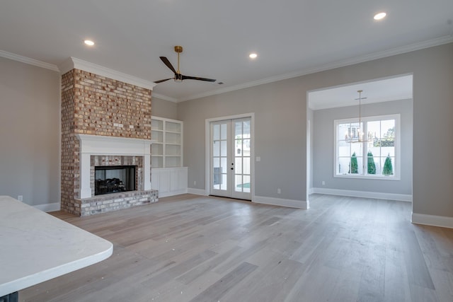 unfurnished living room featuring crown molding, plenty of natural light, french doors, and light hardwood / wood-style flooring