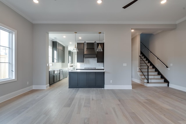 kitchen with pendant lighting, custom exhaust hood, a wealth of natural light, and light hardwood / wood-style flooring