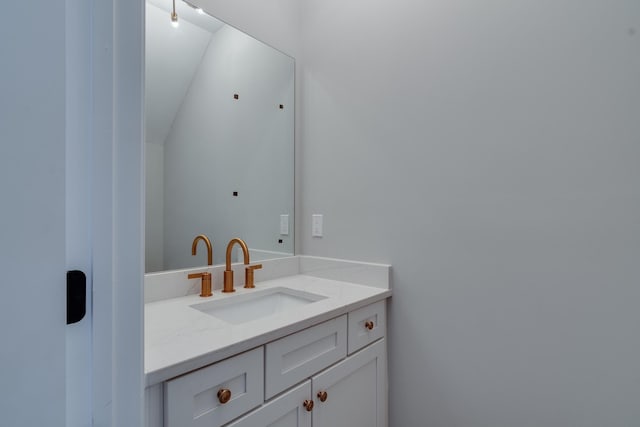 bathroom with vanity and vaulted ceiling