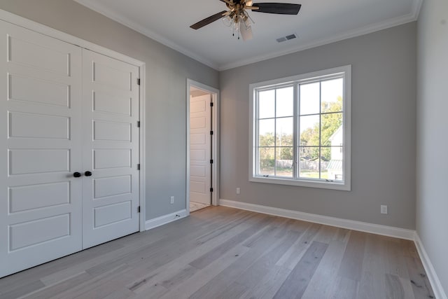 unfurnished bedroom with a closet, light hardwood / wood-style floors, ceiling fan, and ornamental molding