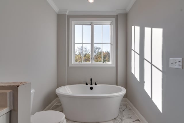 bathroom with toilet, crown molding, and a bathing tub