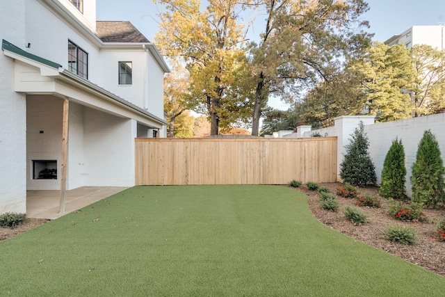 view of yard featuring an outdoor fireplace