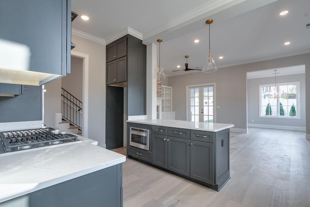 kitchen with french doors, ceiling fan with notable chandelier, hanging light fixtures, light hardwood / wood-style flooring, and appliances with stainless steel finishes