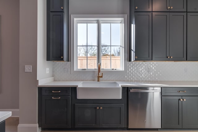 kitchen featuring stainless steel dishwasher, gray cabinetry, sink, and tasteful backsplash