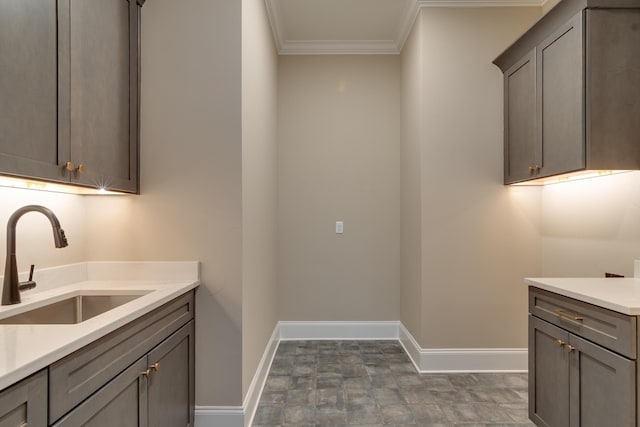 laundry room with crown molding and sink