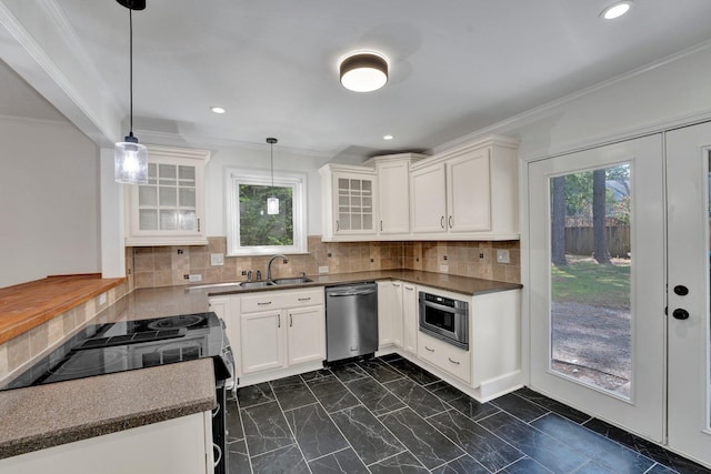 kitchen with hanging light fixtures, appliances with stainless steel finishes, tasteful backsplash, plenty of natural light, and white cabinetry