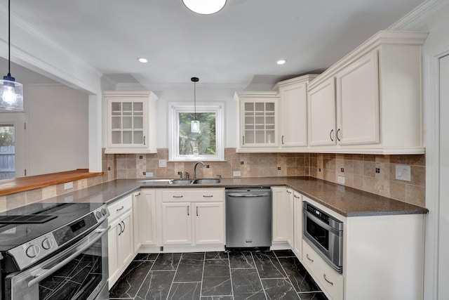 kitchen with appliances with stainless steel finishes, white cabinetry, hanging light fixtures, and sink