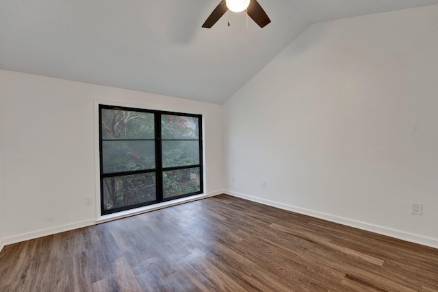 spare room with ceiling fan, lofted ceiling, and dark wood-type flooring