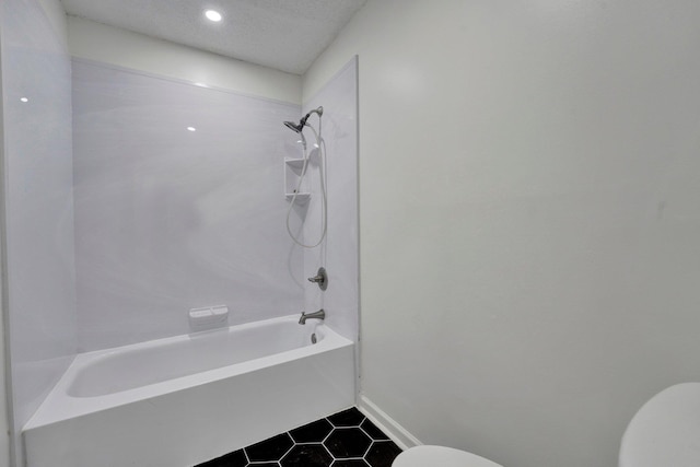 bathroom featuring tile patterned floors,  shower combination, toilet, and a textured ceiling