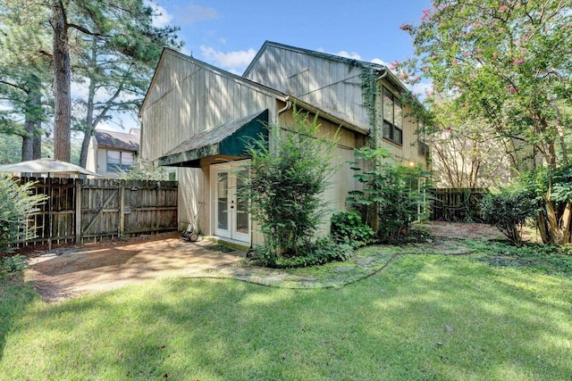 rear view of house featuring french doors and a yard