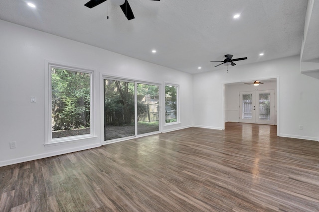 unfurnished living room featuring dark hardwood / wood-style floors, ceiling fan, a textured ceiling, and french doors