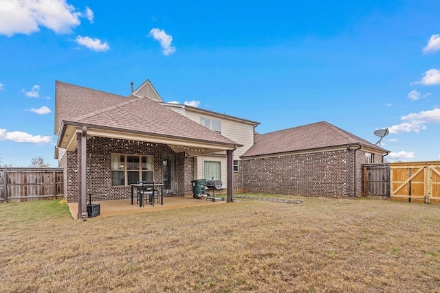 back of house with a yard and a patio