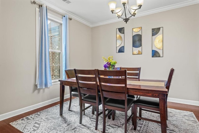 dining room with dark hardwood / wood-style floors, crown molding, and an inviting chandelier