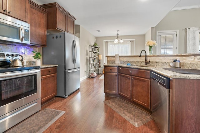 kitchen with sink, dark hardwood / wood-style flooring, a chandelier, decorative backsplash, and appliances with stainless steel finishes