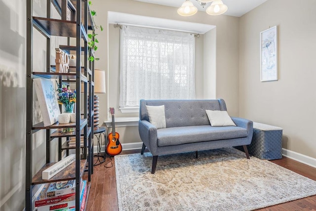 living area with a notable chandelier, plenty of natural light, and dark hardwood / wood-style flooring