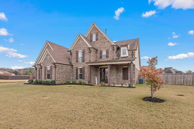 view of property featuring a front lawn and central AC unit