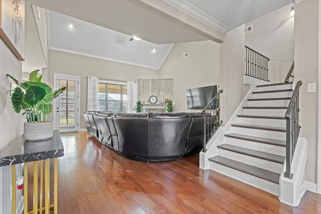 living room with hardwood / wood-style flooring, high vaulted ceiling, and ornamental molding