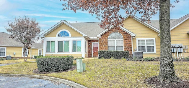 view of front of property featuring a front yard and central air condition unit