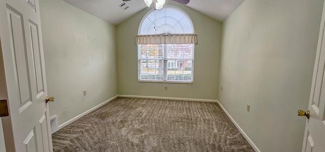 carpeted empty room featuring a textured ceiling and vaulted ceiling