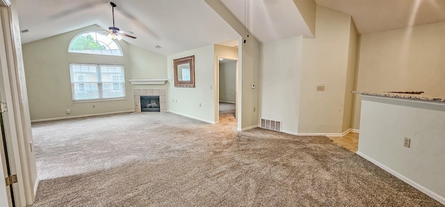 unfurnished living room with light colored carpet, high vaulted ceiling, ceiling fan, and a tiled fireplace