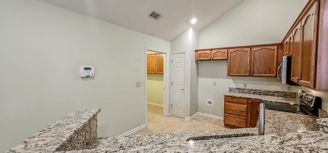 kitchen featuring stainless steel appliances, sink, stone countertops, high vaulted ceiling, and light tile patterned flooring