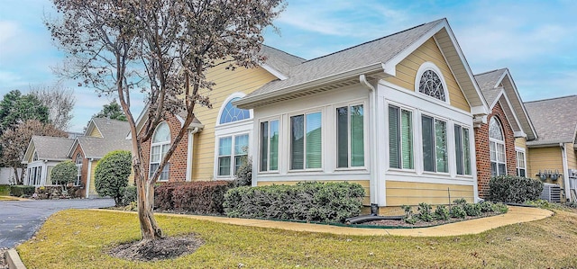 view of home's exterior with central AC unit and a lawn