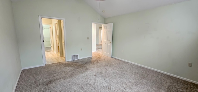 unfurnished bedroom featuring light carpet and high vaulted ceiling