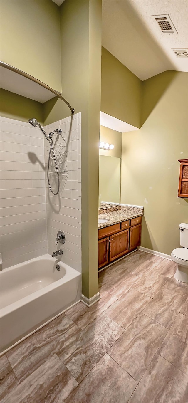 full bathroom featuring a textured ceiling, vanity, toilet, and tiled shower / bath