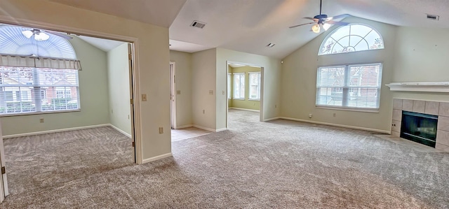 unfurnished living room featuring a tiled fireplace, ceiling fan, and light colored carpet