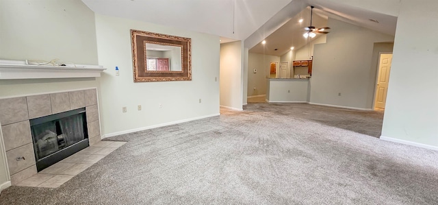 unfurnished living room with ceiling fan, lofted ceiling, light carpet, and a tile fireplace