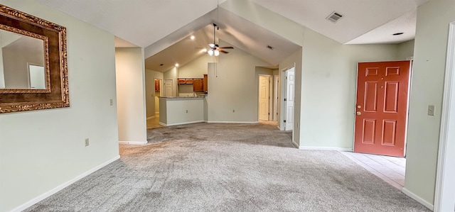 unfurnished living room featuring light colored carpet, vaulted ceiling, and ceiling fan