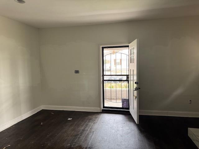 doorway with dark wood-type flooring