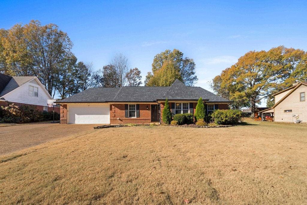 view of front of property featuring a garage and a front lawn