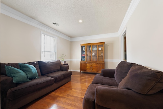 living room featuring hardwood / wood-style floors, a textured ceiling, and ornamental molding