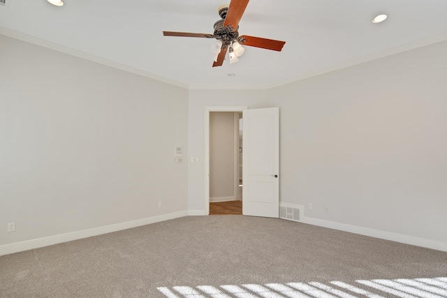 carpeted spare room with ceiling fan and ornamental molding