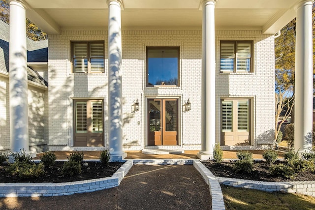 view of exterior entry featuring covered porch