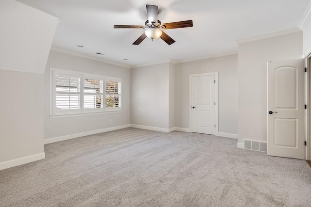 carpeted spare room featuring crown molding and ceiling fan