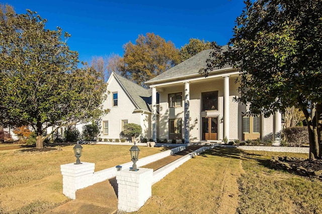 greek revival inspired property featuring a front lawn