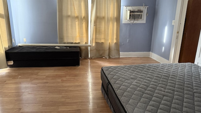 unfurnished bedroom featuring hardwood / wood-style flooring and a wall mounted air conditioner