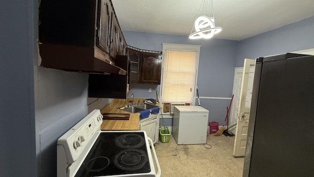 kitchen with dark brown cabinets, pendant lighting, white appliances, and sink