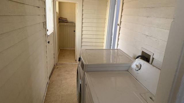 bathroom featuring washing machine and dryer and wooden walls