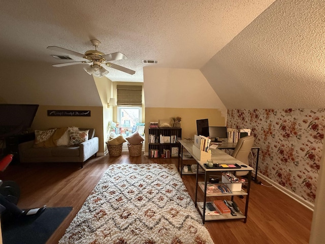 home office featuring ceiling fan, wood-type flooring, a textured ceiling, and vaulted ceiling