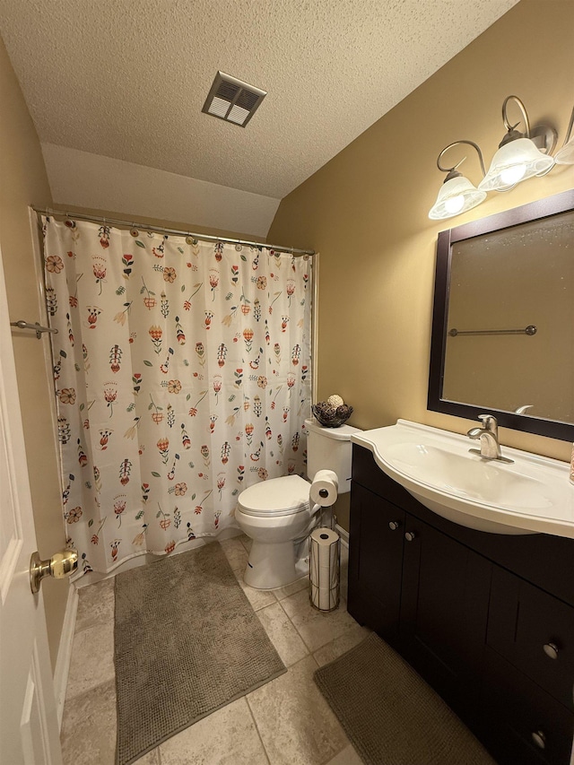 bathroom with tile patterned floors, vanity, toilet, and a textured ceiling