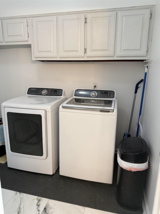 laundry area featuring washing machine and dryer and cabinets