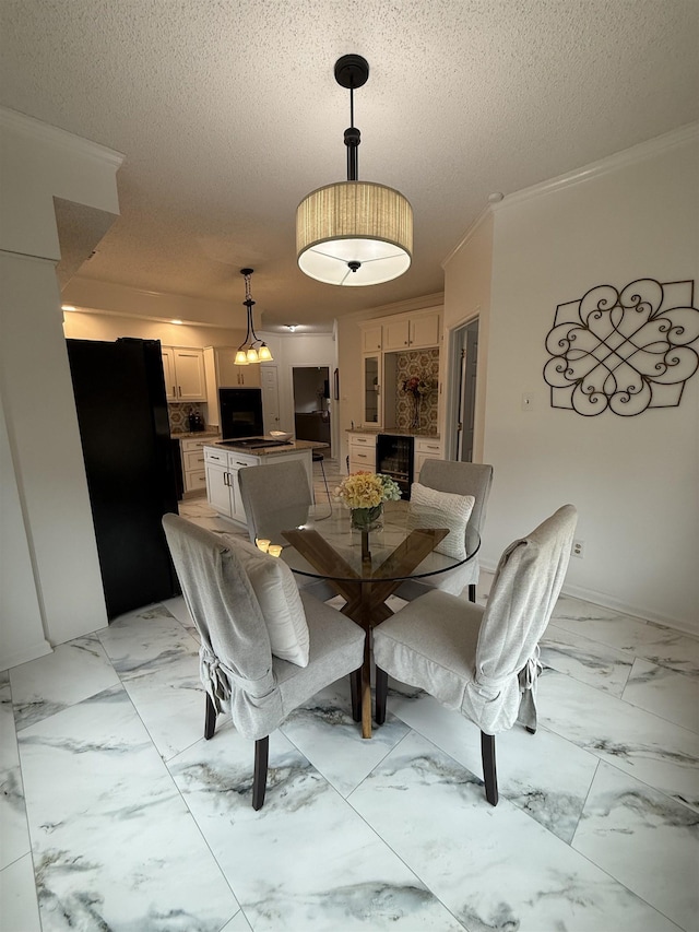 dining space featuring a textured ceiling, wine cooler, and ornamental molding