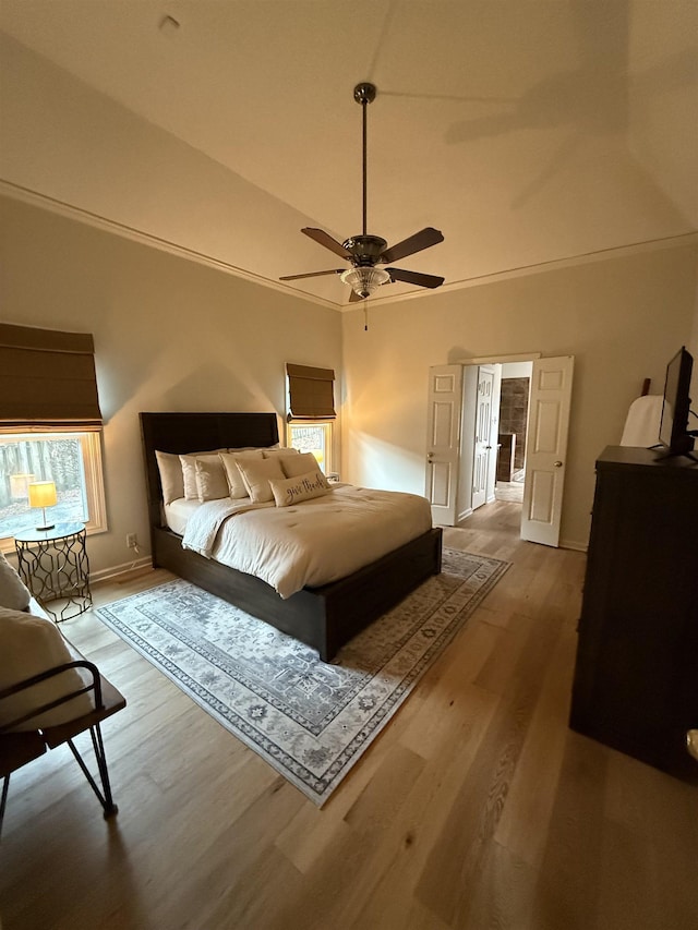 bedroom featuring wood-type flooring, multiple windows, ornamental molding, and ceiling fan